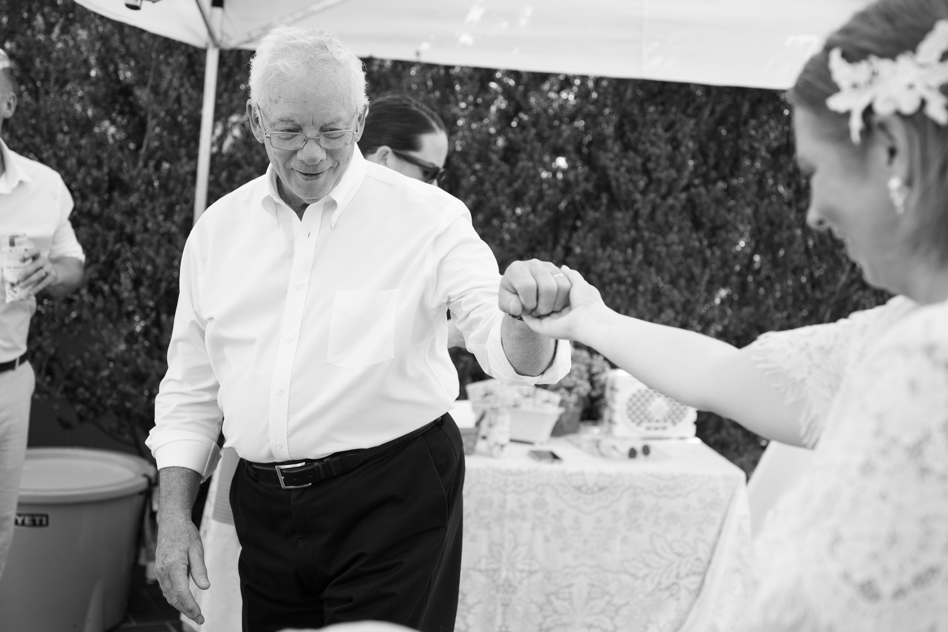 Black-and-white frame of the bride dancing with her father under the reception tent